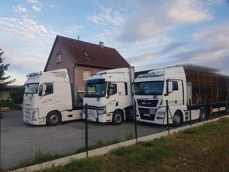 Trois tracteurs de Transports Brun avec des semi-remorques chargées de caisses grillagées