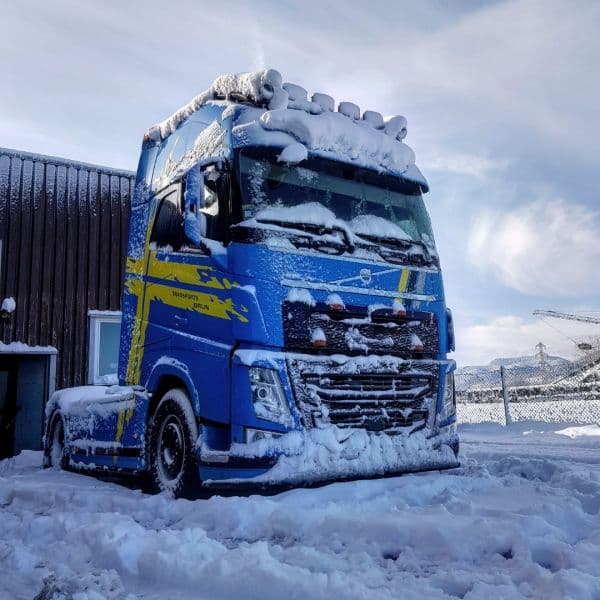 Tracteur Volvo FH bleu recouvert de neige