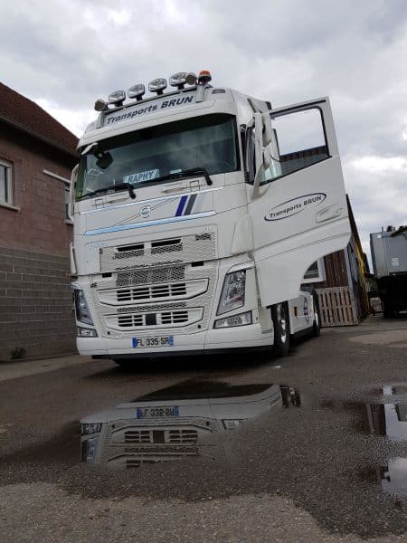 Tracteur Volvo FH portes ouvertes, se reflétant dans une flaque