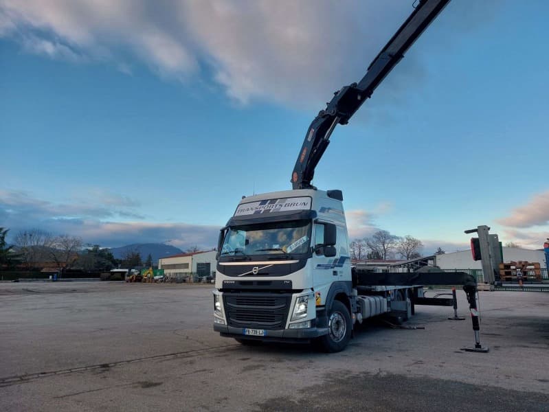 Camion-grue Volvo FM, grue dressée, sur une aire de stationnement au petit matin
