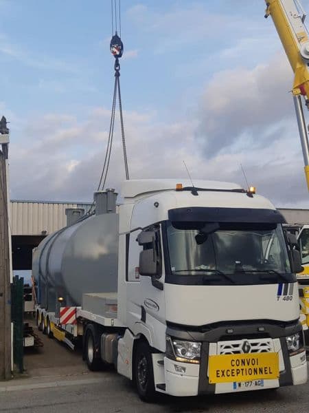 Convoi exceptionnel : cuve métallique levée à la grue au-dessus d’une semi-remorque Renault